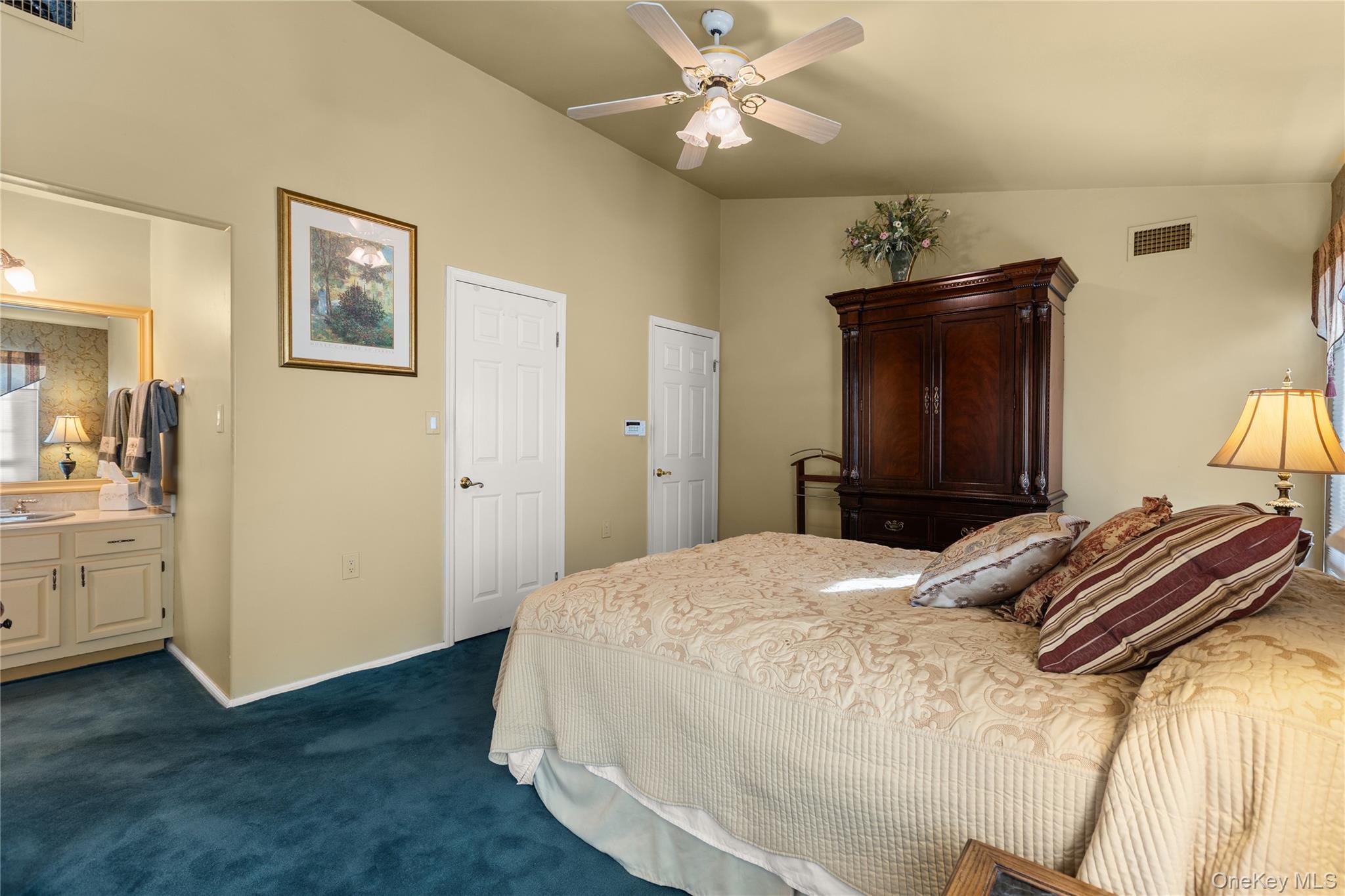 77 Glen Drive Ridge, NY 11961 - Photo 17 of 27 a bedroom with a bed and a chandelier