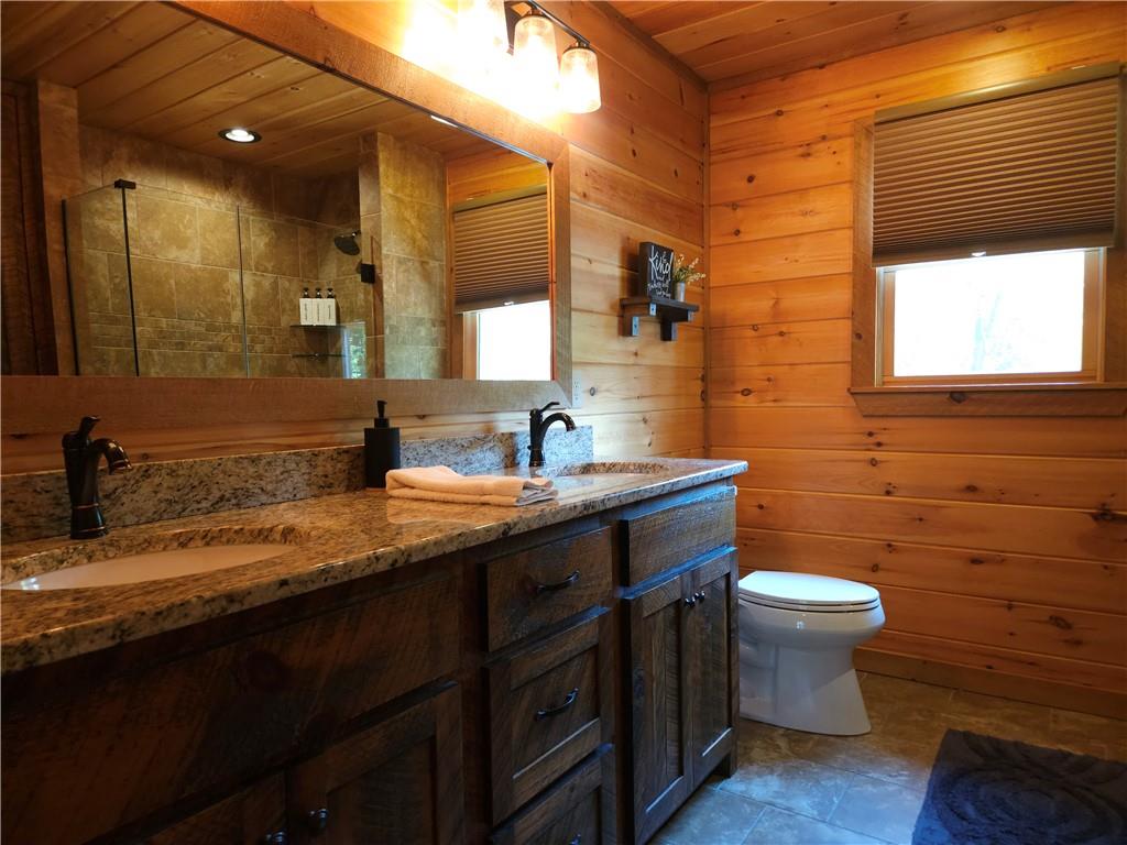 101 Hothouse Drive Mineral Bluff, GA 30559 - Photo 32 of 63 a bathroom with a granite countertop sink a toilet and a mirror