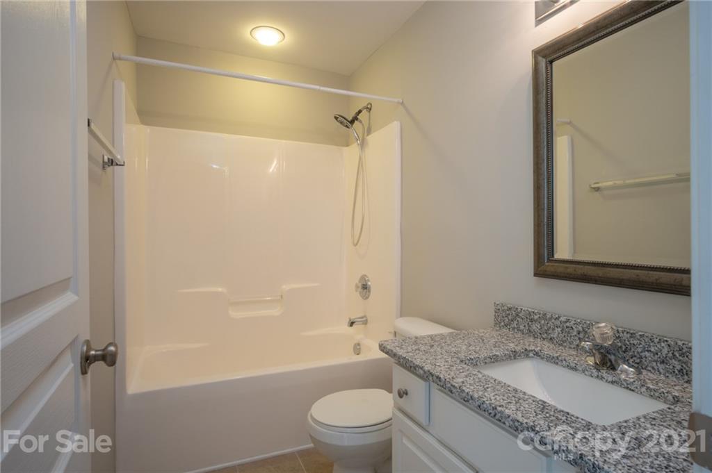 914 Copperstone Lane, Unit 177 Fort Mill, SC 29708 - Photo 17 of 27 a bathroom with a granite countertop sink toilet and shower