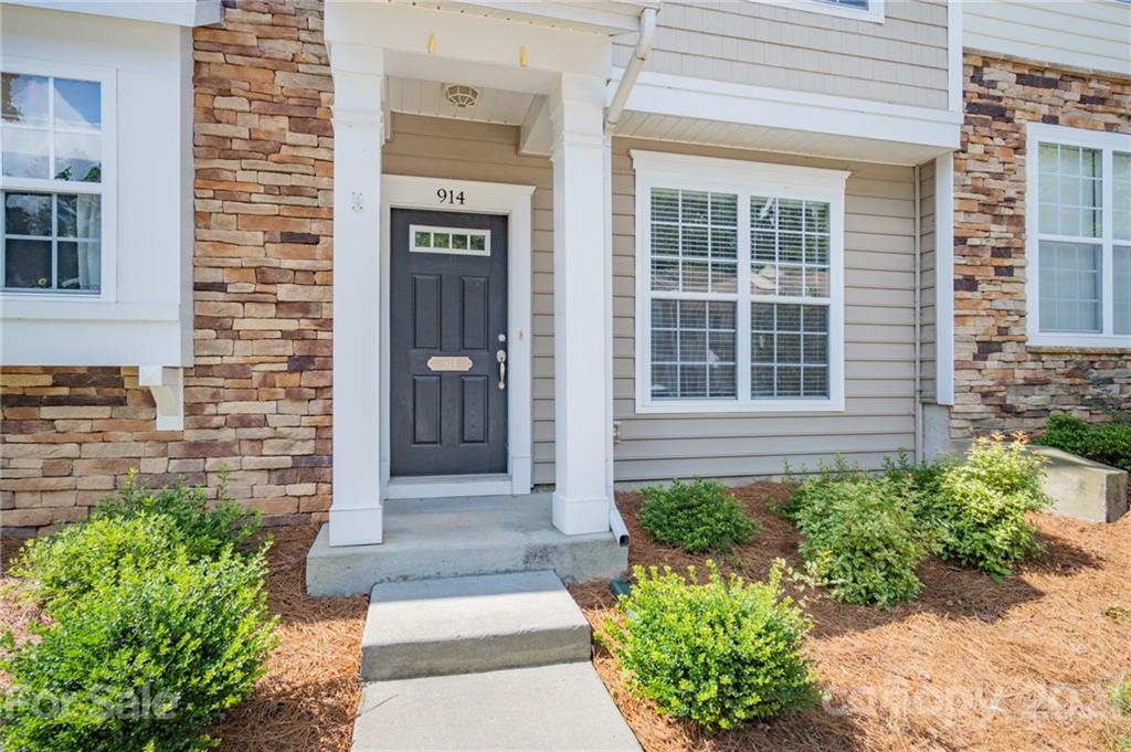 914 Copperstone Lane, Unit 177 Fort Mill, SC 29708 - Photo 3 of 27 a house with potted plants in front of door