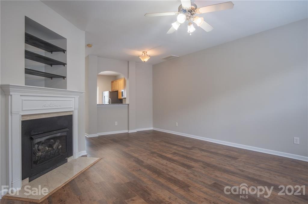 914 Copperstone Lane, Unit 177 Fort Mill, SC 29708 - Photo 4 of 27 a view of an empty room with wooden floor fireplace and a window