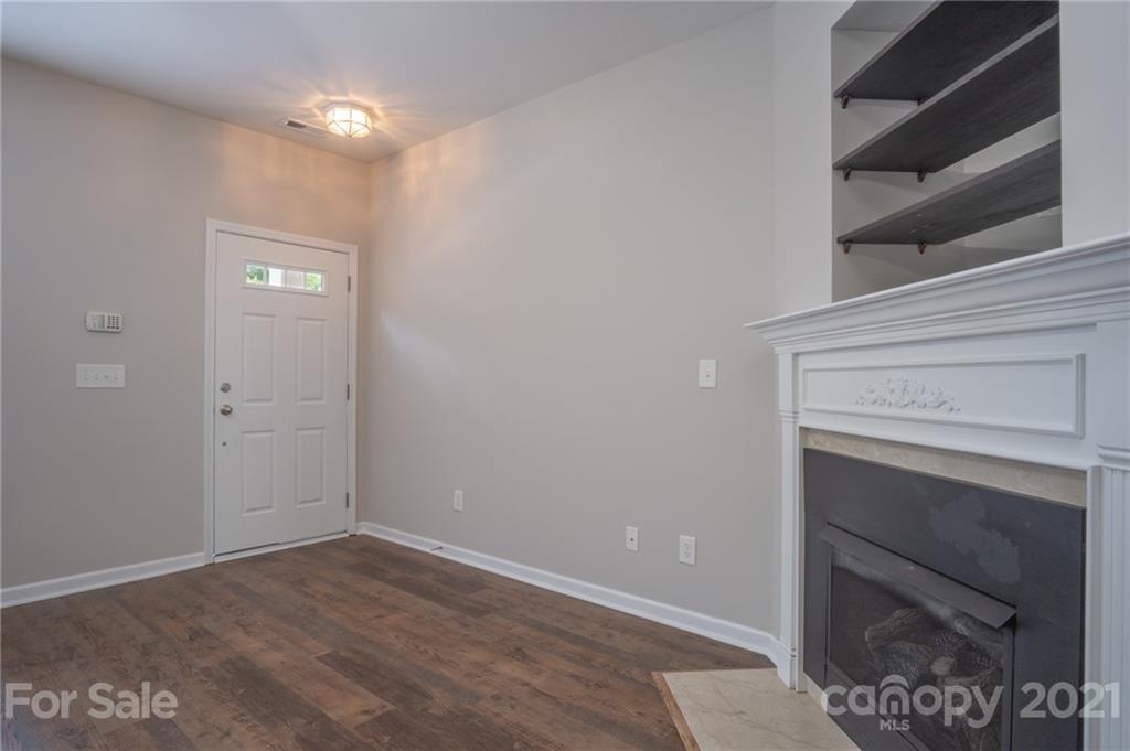 914 Copperstone Lane, Unit 177 Fort Mill, SC 29708 - Photo 5 of 27 a view of an empty room with wooden floor and a fireplace