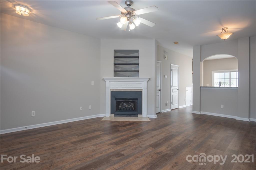 914 Copperstone Lane, Unit 177 Fort Mill, SC 29708 - Photo 7 of 27 a view of an empty room with wooden floor fireplace and a window
