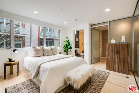 a bedroom with a large bed and large window