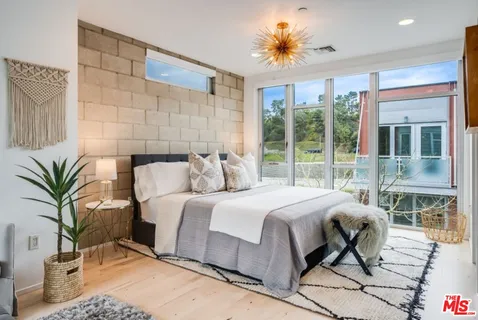 a large bedroom with a bed and large windows