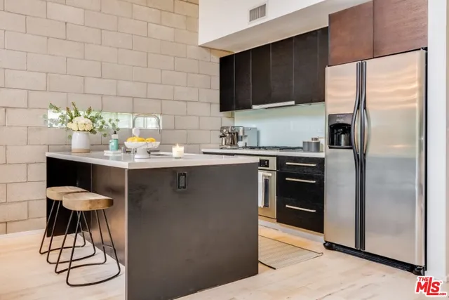 a kitchen with stainless steel appliances a sink a table and chairs