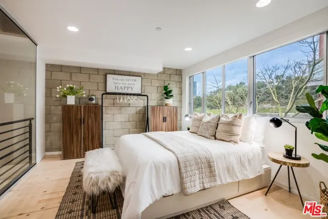 a spacious bedroom with a large bed and a chandelier