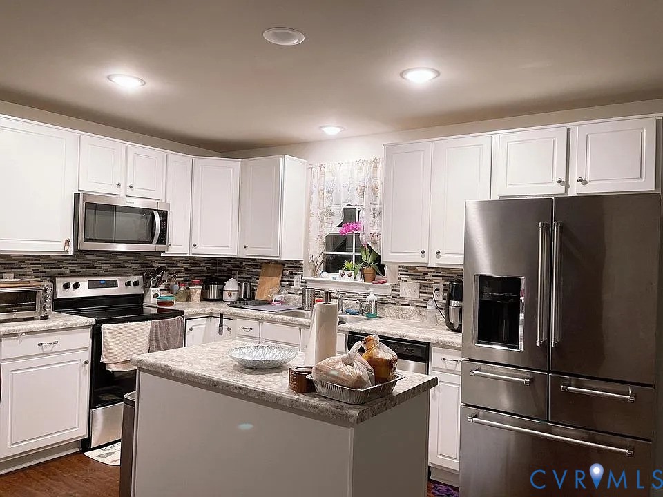 4820 Bethlehem Road Richmond, VA 23230 - Photo 5 of 13 Kitchen featuring white cabinetry, a central islan