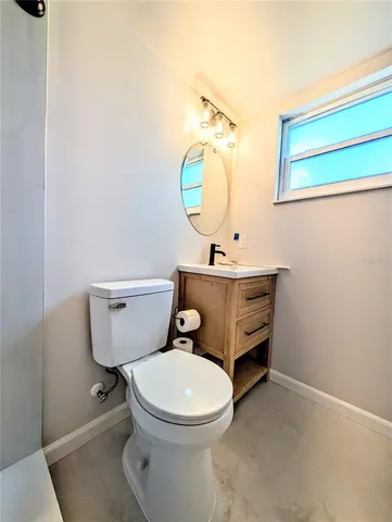 a bathroom with a toilet a sink and mirror