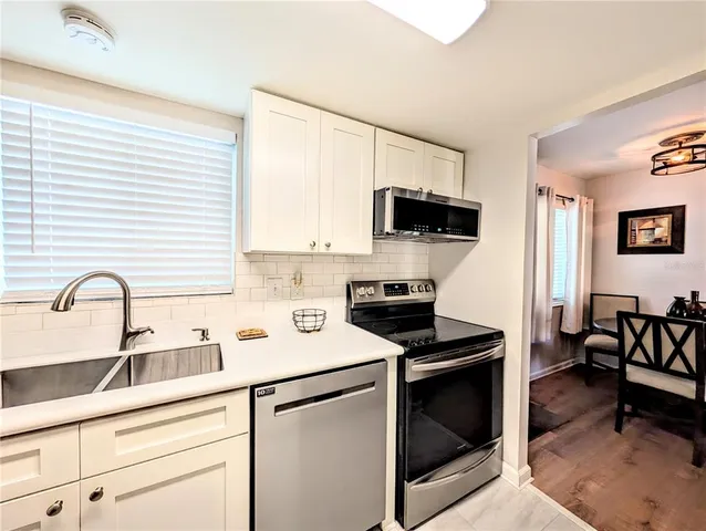 a kitchen with stainless steel appliances a stove microwave and sink