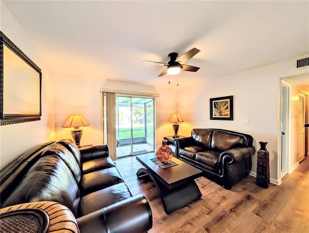 a living room with furniture ceiling fan and a window