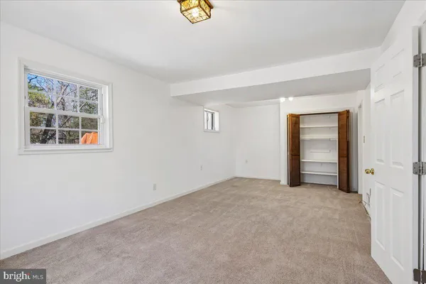 an empty room with windows and closet