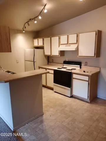 a kitchen with stainless steel appliances granite countertop a sink a stove and a refrigerator