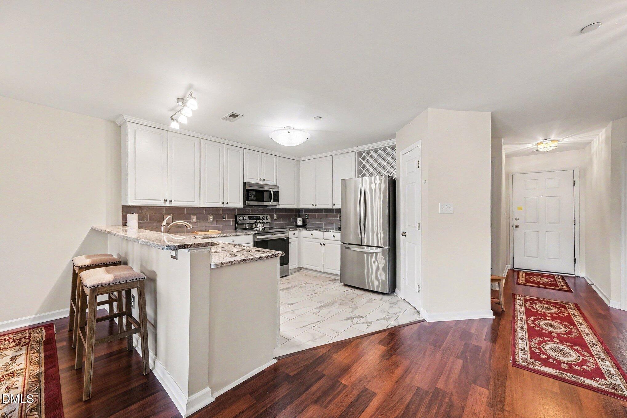 132 Springfork Drive Cary, NC 27513 - Photo 17 of 28 a kitchen with stainless steel appliances a refrigerator and a stove top oven