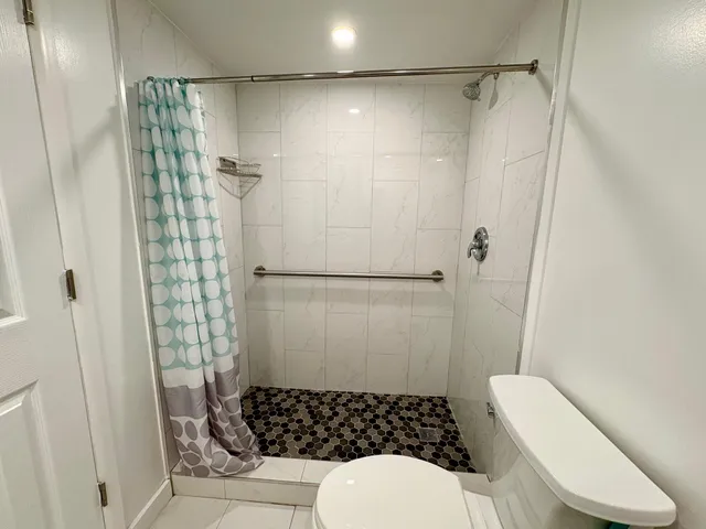 a bathroom with a toilet and a shower