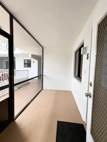 a view of a hallway to a livingroom with furniture
