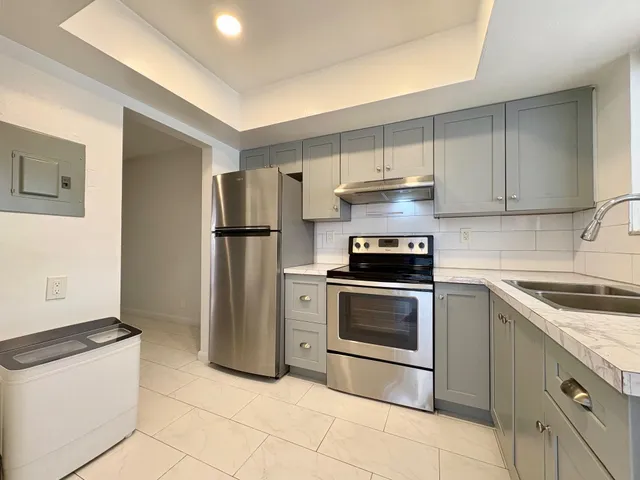 a kitchen with granite countertop a stove and a refrigerator