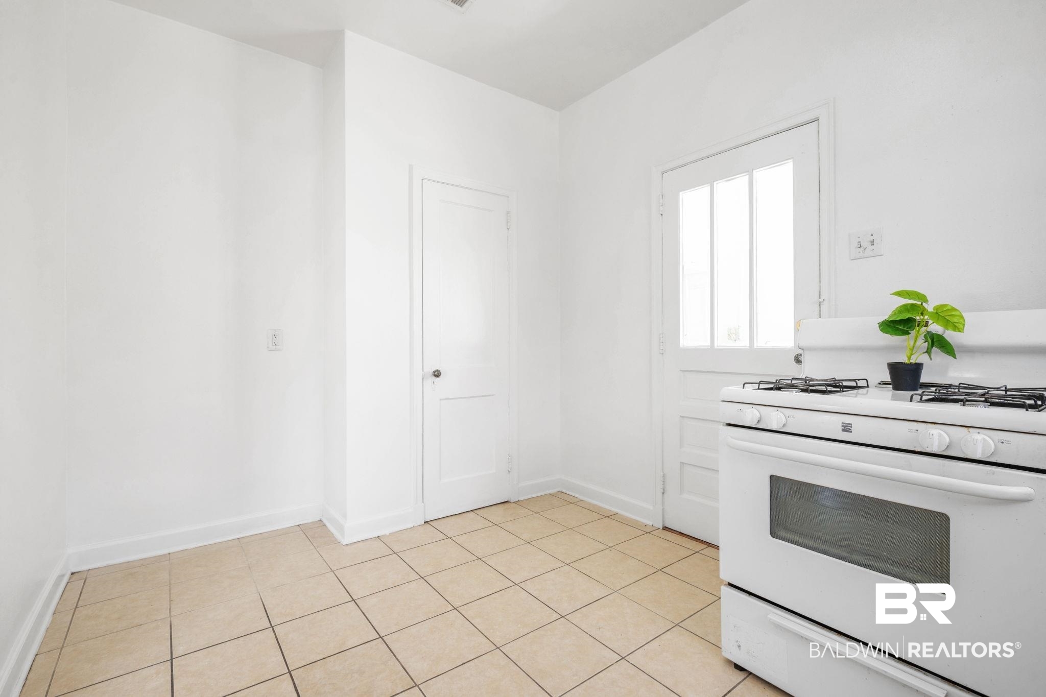 1707 Church Street Mobile, AL 36604 - Photo 21 of 43 Kitchen featuring light tile patterned floors, white range with gas cooktop, and baseboards