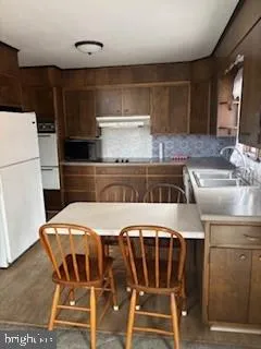 a kitchen with a table chairs and a refrigerator