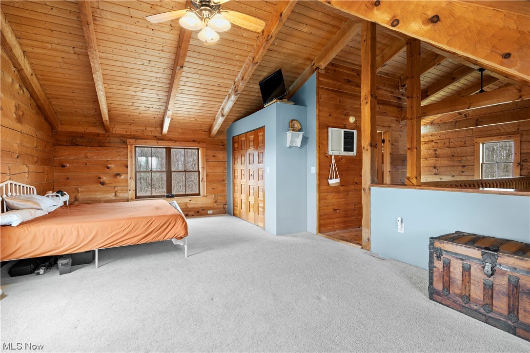 9485 Stone Road Litchfield, OH 44253 - Photo 32 of 50 Carpeted bedroom with wood walls, ceiling fan, lofted ceiling with beams, and wood ceiling