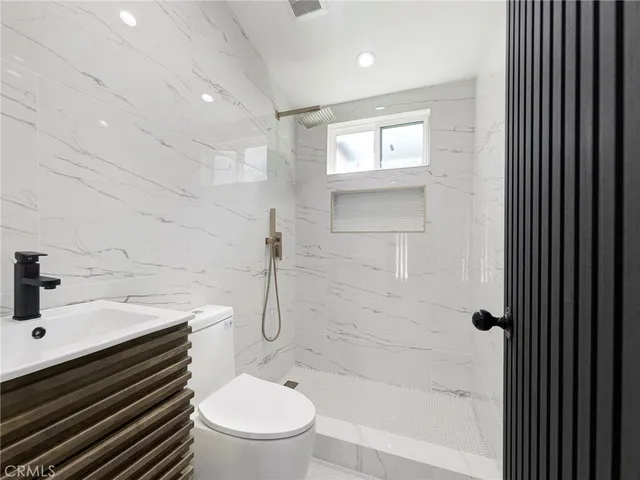 a bathroom with a sink a toilet and shower