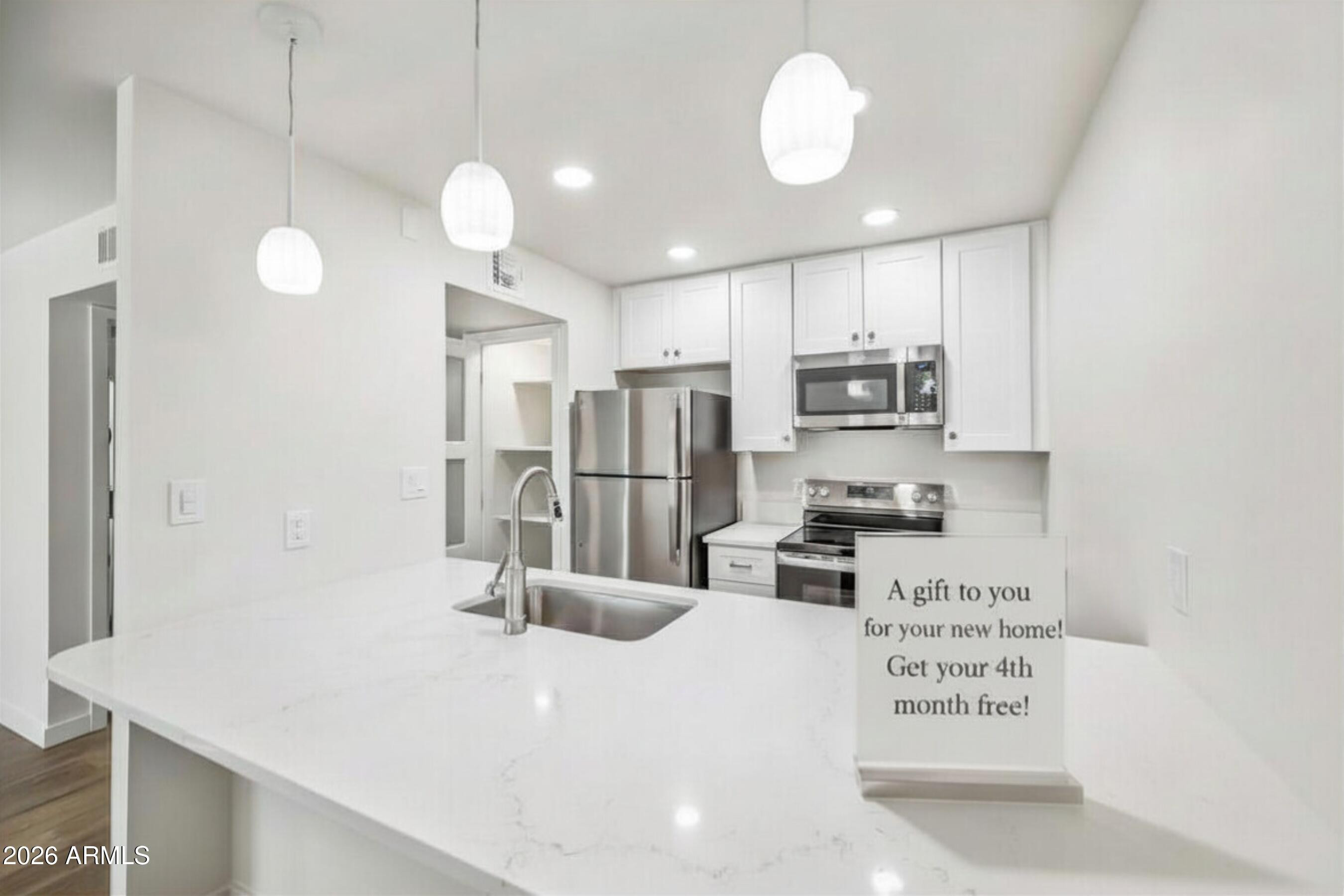 a kitchen with stainless steel appliances a refrigerator sink and microwave