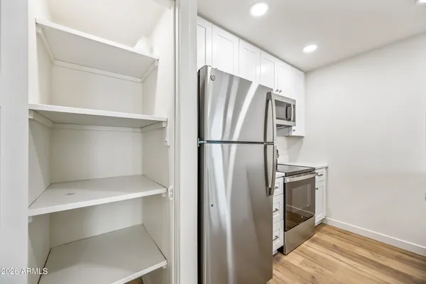 a view of kitchen with stainless steel appliances wooden floor and staircase