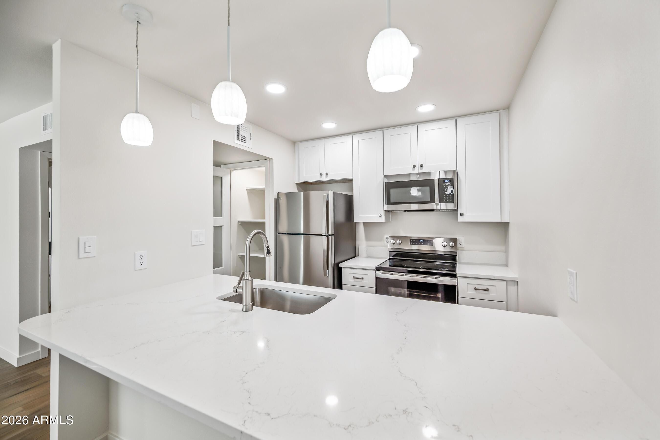 4139 North 27th Street, Unit 3 Phoenix, AZ 85016 - Photo 9 of 30 a kitchen with stainless steel appliances a stove sink and refrigerator