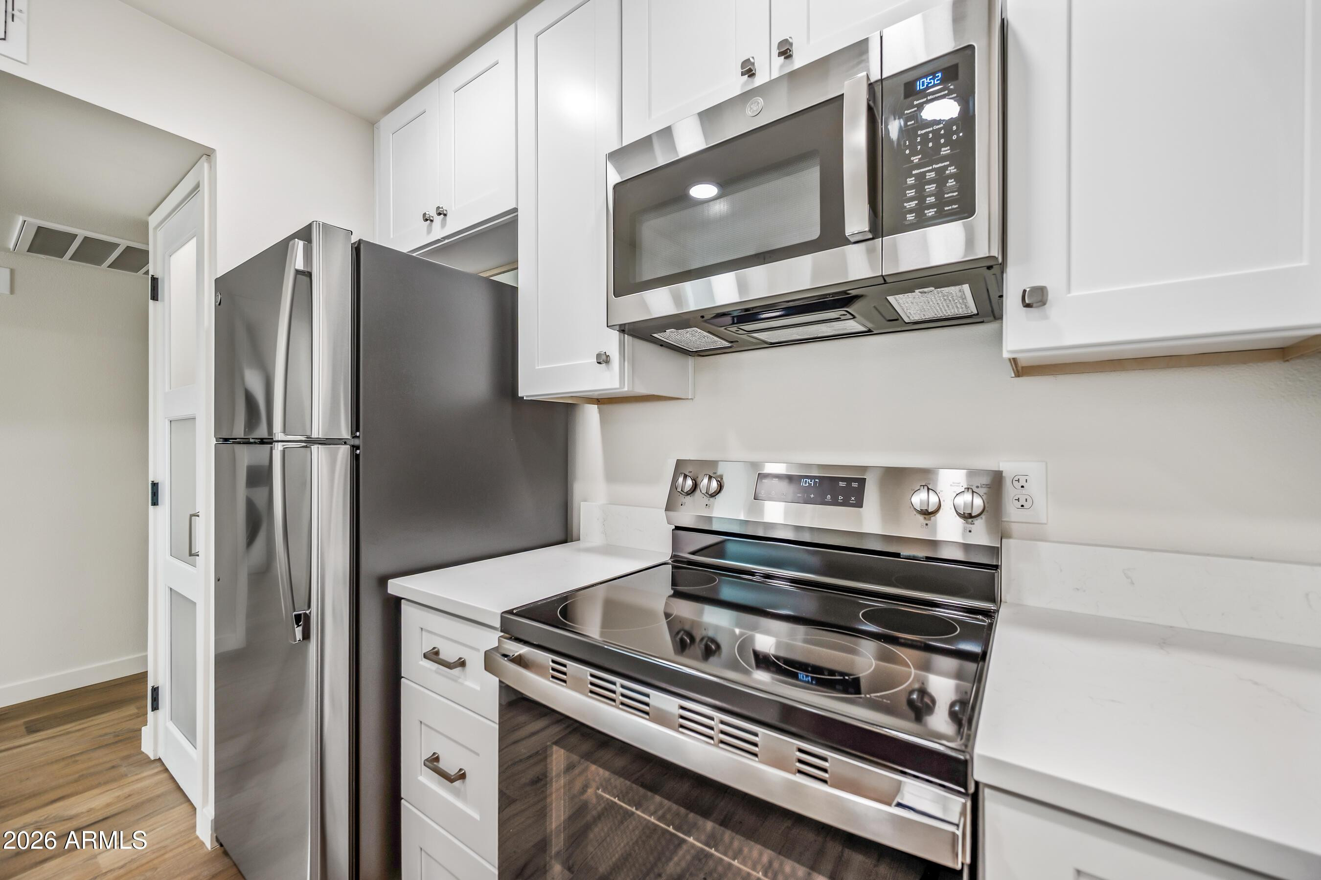 4139 North 27th Street, Unit 3 Phoenix, AZ 85016 - Photo 10 of 30 a kitchen with stainless steel appliances granite countertop a stove microwave and refrigerator