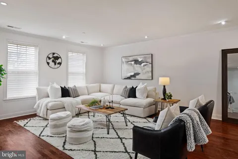a living room with furniture kitchen view and a large window