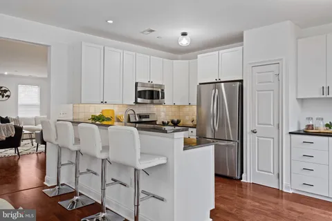 a kitchen with cabinets stainless steel appliances and a sink