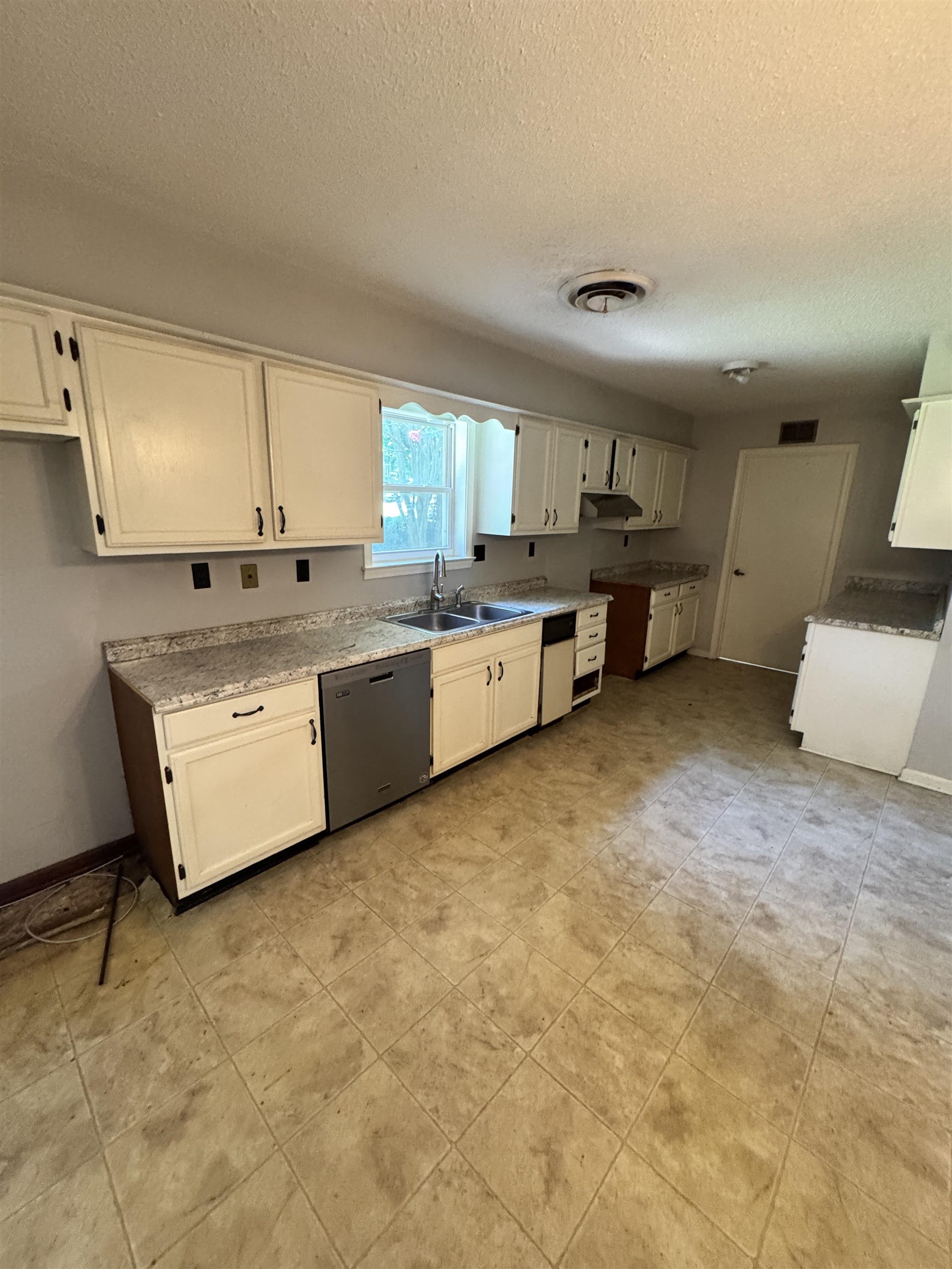 4334 Timber Rise Road Memphis, TN 38125 - Photo 7 of 18 Kitchen featuring white cabinetry, light-toned countertops, a stainless steel dishwasher, a double basin sink, and tile flooring