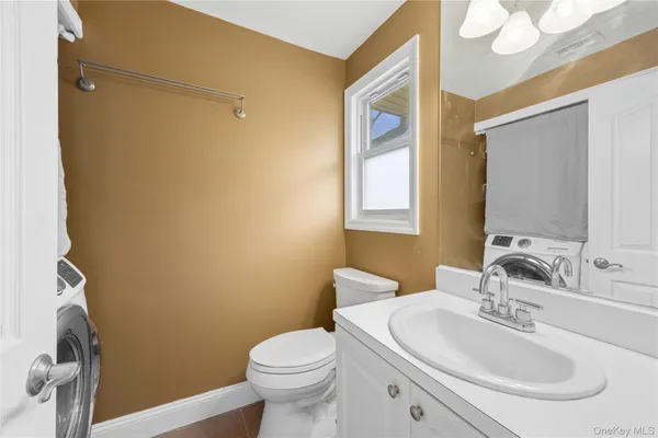 a bathroom with a sink mirror vanity and toilet