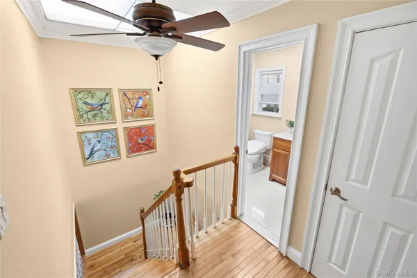 a view of a hallway with wooden floor and staircase