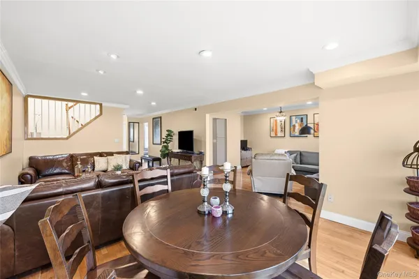 a living room with furniture a dining table and a chandelier