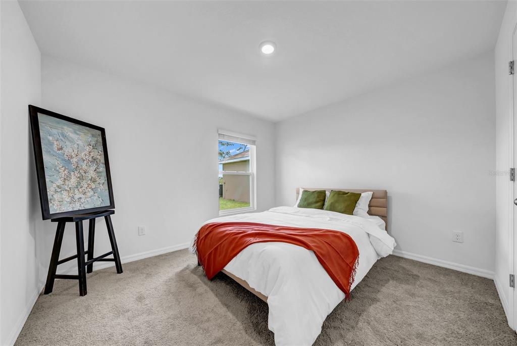 13295 Mylion Way Spring Hill, FL 34610 - Photo 28 of 68 a bedroom with a bed and a lamp on table