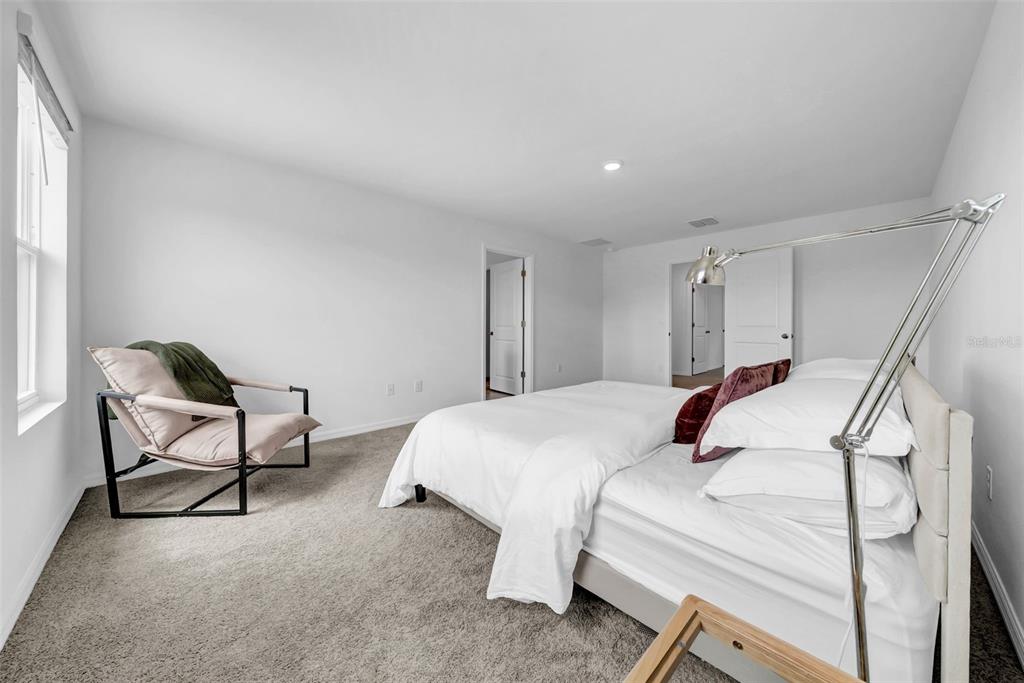 13295 Mylion Way Spring Hill, FL 34610 - Photo 35 of 68 a bedroom with a bed and a chair