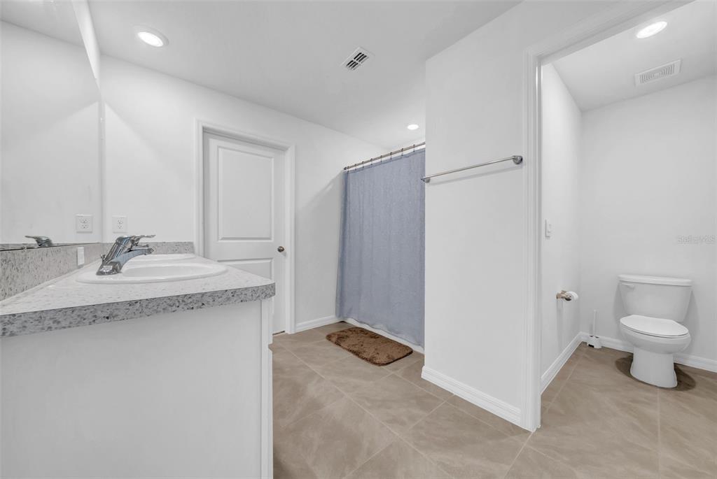 13295 Mylion Way Spring Hill, FL 34610 - Photo 37 of 68 a bathroom with a granite countertop sink toilet and shower