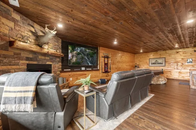 a living room with stainless steel appliances furniture wooden floor and a kitchen view