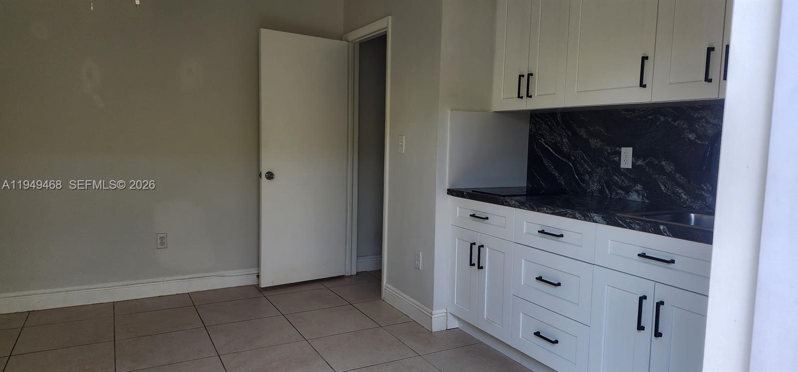 6265 Southwest 31st Street, Unit B Miami, FL 33155 - Photo 13 of 26 a kitchen with white cabinets and a wooden floor