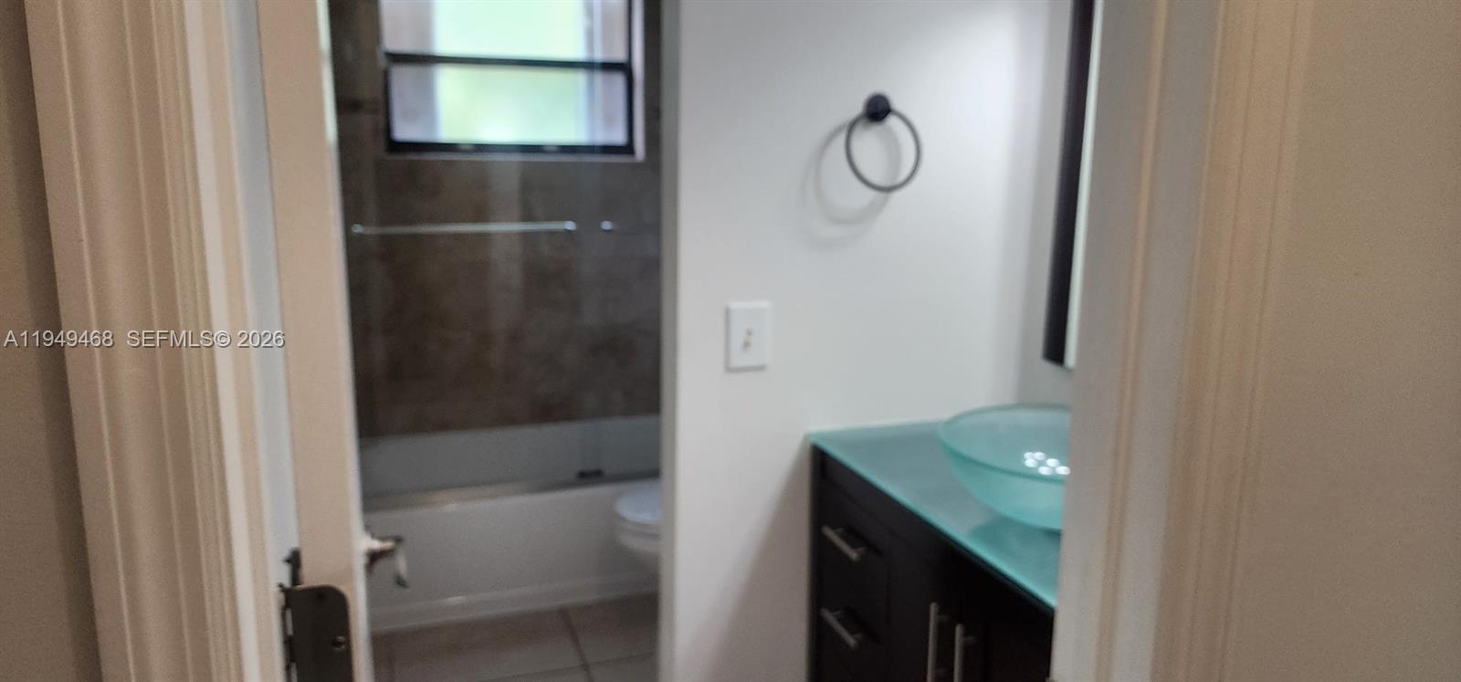 6265 Southwest 31st Street, Unit B Miami, FL 33155 - Photo 19 of 26 a bathroom with a glass shower door and a sink