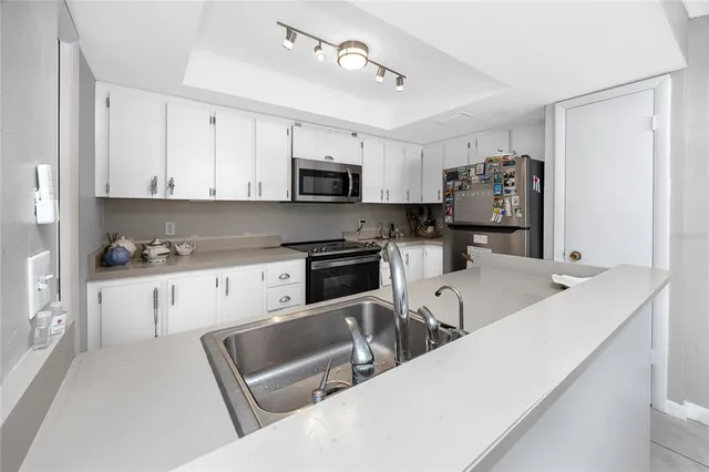 a kitchen with kitchen island white cabinets and stainless steel appliances