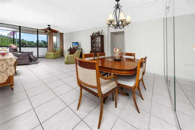 a living room with furniture a chandelier and a dining table