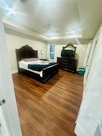 a large bedroom with a bed and flat screen tv