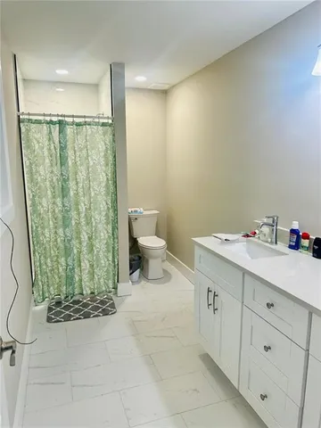 a bathroom with a sink a toilet and shower