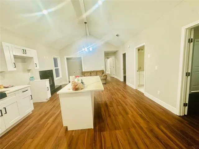 a large white kitchen with wooden floors and a fireplace