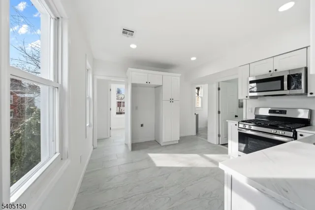a view of kitchen with sink refrigerator and window