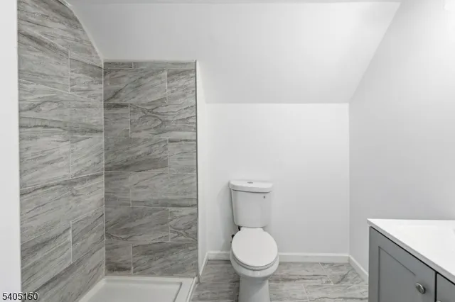 a bathroom with a granite countertop toilet and a sink