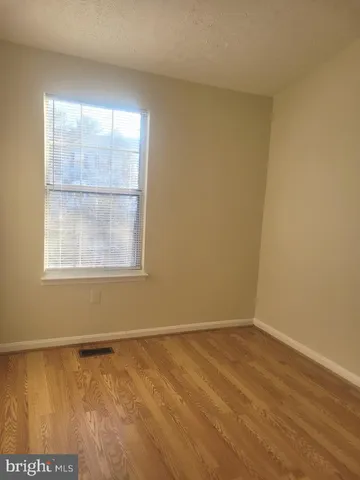 a view of an empty room with closet and a window