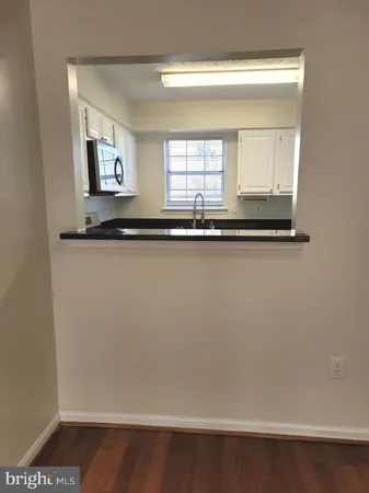 a large kitchen with granite countertop a stove a microwave and a sink